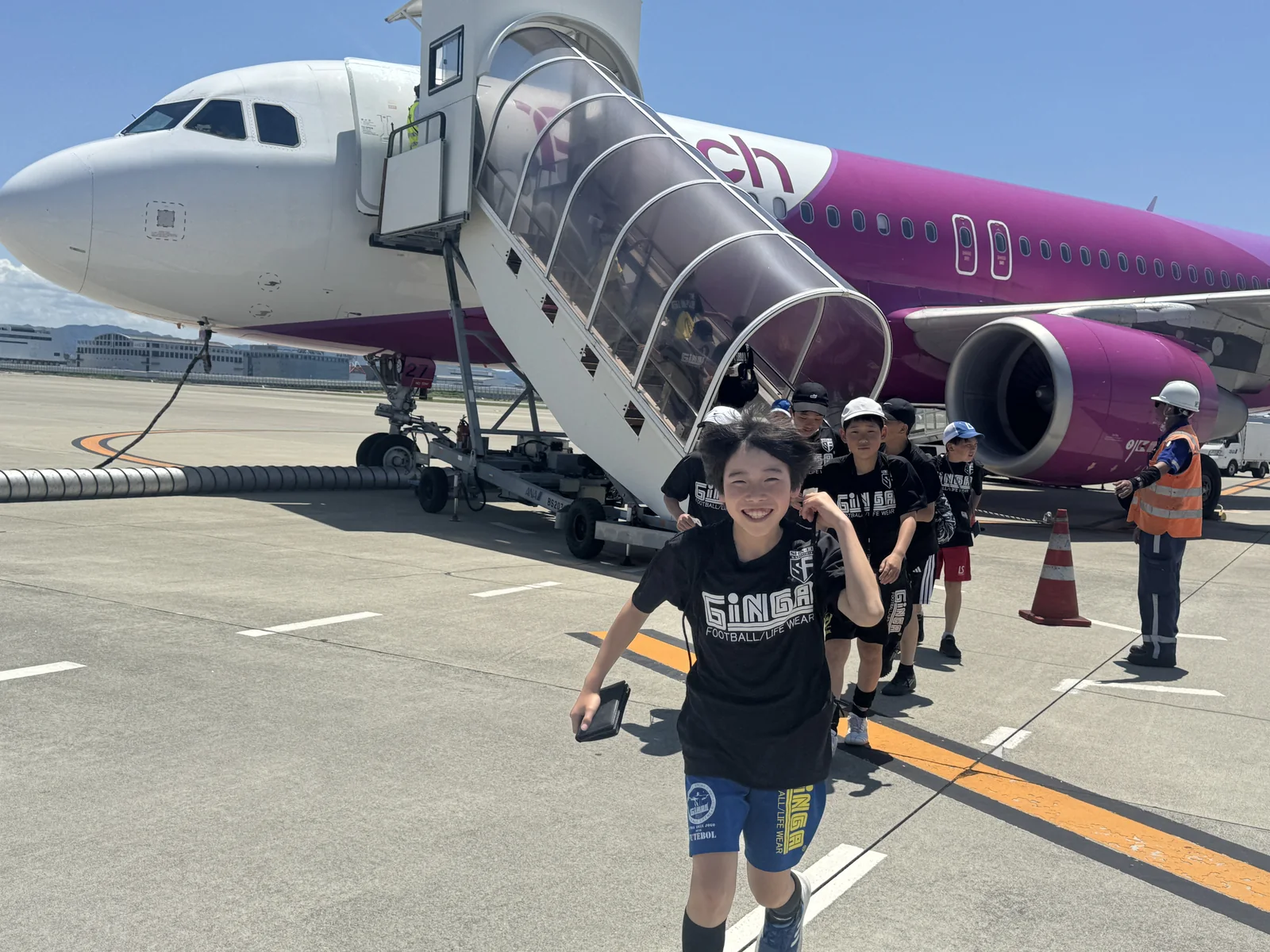 飛行機への搭乗前に集まった真栄FCの選手たち