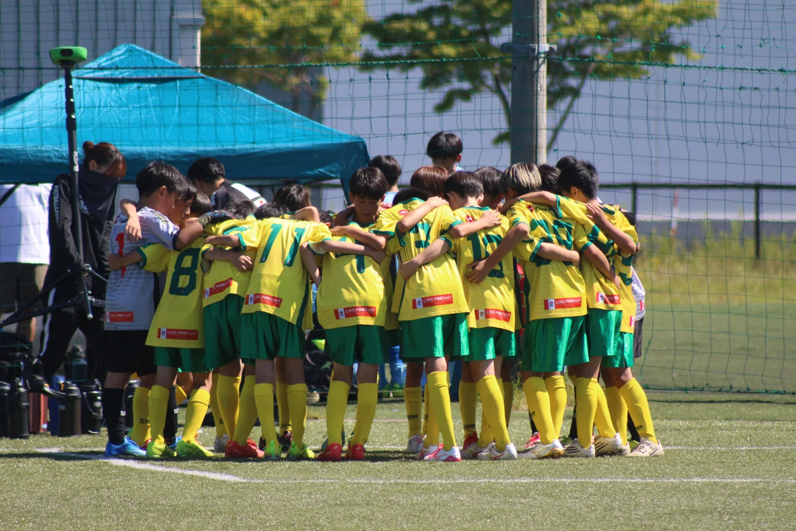肩を組んで円陣をつくる真栄FCの選手たち